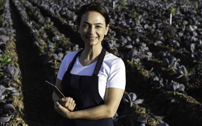 Sales Tools - Lady standing in a field with an ipad, smiling.